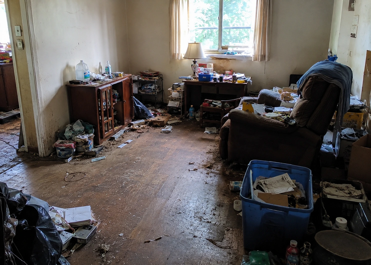 Illustrative moderate cluttered room with open floor areas and household items still requiring sorting.